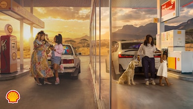 Shell campaign image set at a service station during golden-hour light. The left side shows a person standing beside a vintage car at a Shell fuel pump, representing an earlier generation. The right side shows a person refuelling a modern vehicle while accompanied by two dogs, representing a later generation. The image highlights continuity across generations and includes the text: “Over 120 years & we are still here for every Mzansi generation. You can ALWAYS COUNT on us.” Shell branding appears in the bottom left