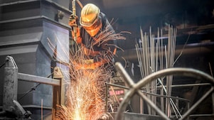 A boiler maker fabricating steel using a flame cutting torch to cut pieces and bend the pieces into shape