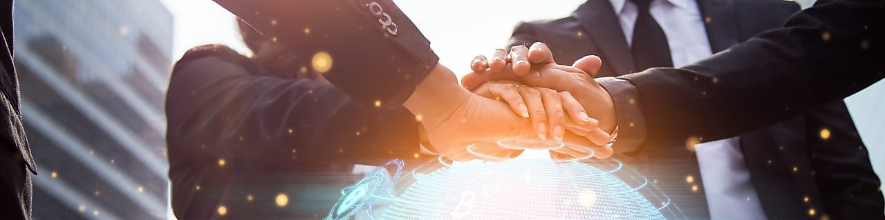 Multiracial colleagues joining hands on a digital globe