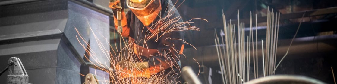 A boiler maker fabricating steel using a flame cutting torch to cut pieces and bend the pieces into shape