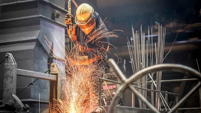 A boiler maker fabricating steel using a flame cutting torch to cut pieces and bend the pieces into shape