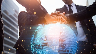 Multiracial colleagues joining hands on a digital globe