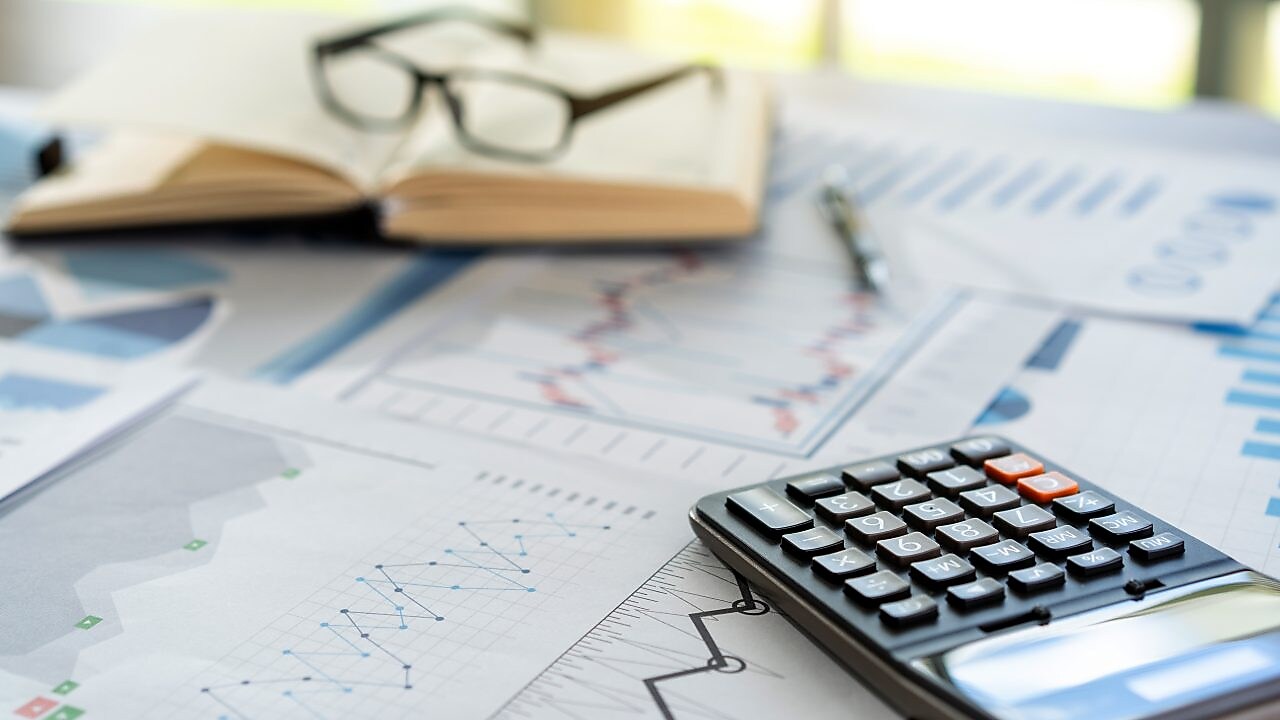 Different line graphs showing trends next to a calculator