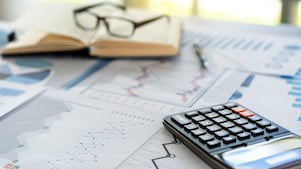 Different line graphs showing trends next to a calculator