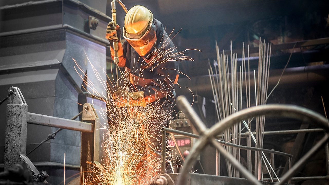 A boiler maker fabricating steel using a flame cutting torch to cut pieces and bend the pieces into shape