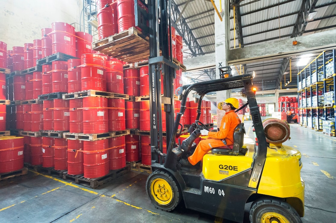 Man picking barrels lubricants