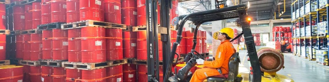 Man picking barrels lubricants