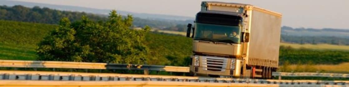 Truck driving on highway, green country background