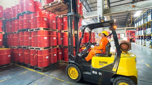 Man picking barrels lubricants
