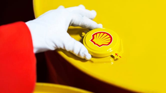 A Shell expert adjusts the lid of a barrel of lubricant displaying the Shell logo
