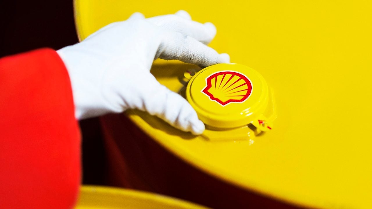 A Shell expert adjusts the lid of a barrel of lubricant displaying the Shell logo