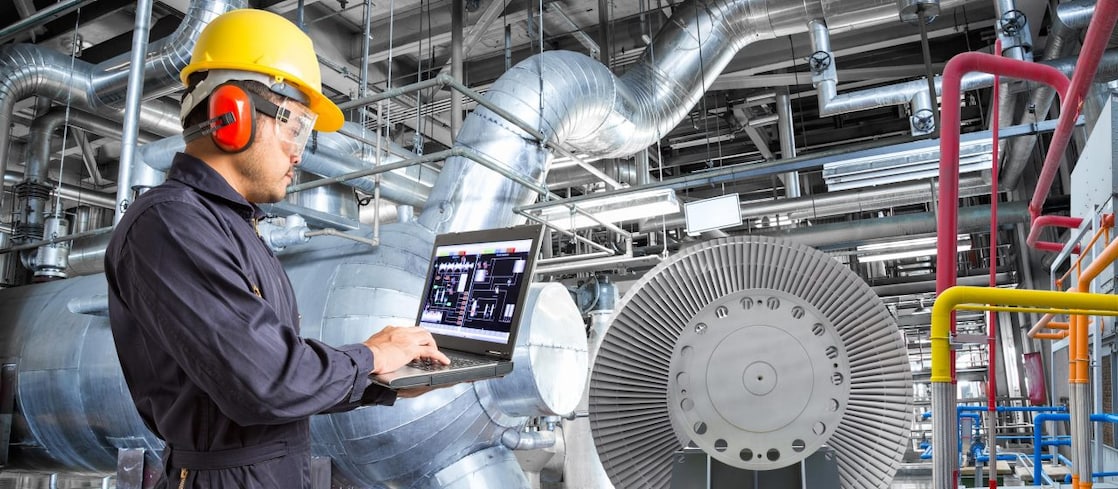 Engineer using laptop computer for maintenance in thermal power plant