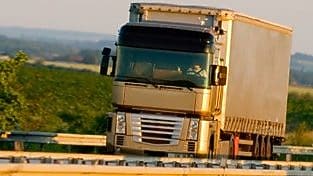 Truck driving on highway, green country background