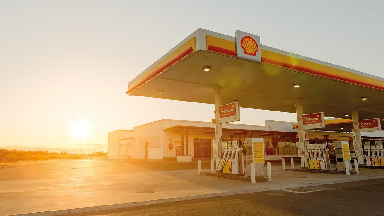 Sun rising behind a Shell station forecourt