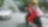 Red motorcycle and rider on a road with cars and buildings in the background