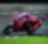 A red Ducati MotoGP bike taking a sharp turn on a race track