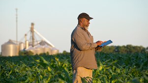 Man walikng in farm using tablet